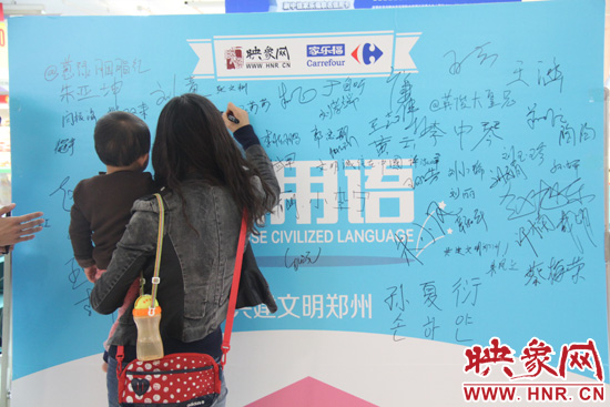 市民在活動(dòng)簽名板上簽字支持使用文明用語