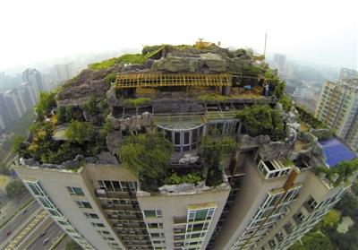 　　昨日，身穿橘黃色馬甲的工作人員在人濟(jì)山莊樓頂拆除違章建筑。新京報(bào)記者 吳江 攝