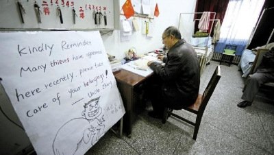 張大爺在門(mén)衛(wèi)室里工作，旁邊是紅爆網(wǎng)絡(luò)的溫馨提示牌記者