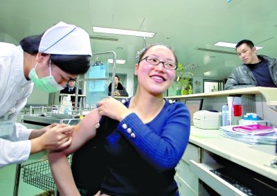 昨日，向雪敏在同濟醫(yī)院血液科病房打動員劑，丈夫陳武右在身后注視著妻子 記者傅克強