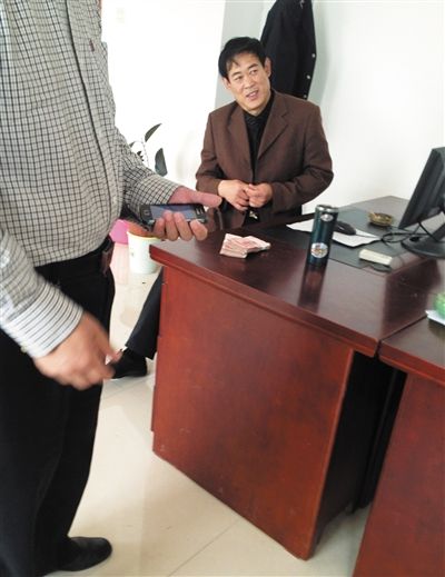 10月29日，獻(xiàn)縣國稅局稽查局辦公室內(nèi)，一名企業(yè)主交了兩萬元現(xiàn)金在桌上。新京報(bào)記者 孟祥超 攝