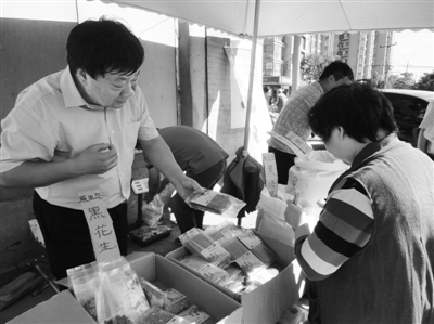 昨日，河南企業(yè)家劉春喜在京“練攤”，為顧客挑選綠豆。新京報記者 張玉學 攝