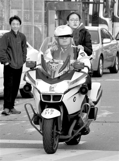 7日，首爾，警察將一名考生送抵考場。新華社發(fā)