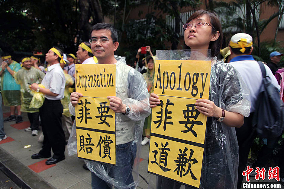 　圖為當(dāng)天下午，當(dāng)臺(tái)灣數(shù)百漁民在馬尼拉經(jīng)濟(jì)文化辦事處前抗議時(shí)，有兩名年輕人手持標(biāo)語，在路邊聲援。中新