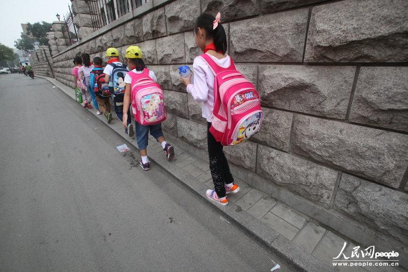 2013年09月11日，濟(jì)南運(yùn)署街上，小學(xué)生走史上“最窄人行道”上學(xué)。