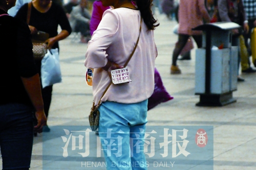 火車站廣場(chǎng)，一女子拿著寫有不同房型價(jià)位的卡片在拉客，不少市民抱怨，受過(guò)此類“騷擾”