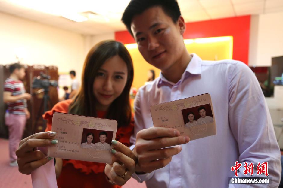 5月20日,河南鄭州,一對(duì)準(zhǔn)新人領(lǐng)完結(jié)婚證后秀自拍。