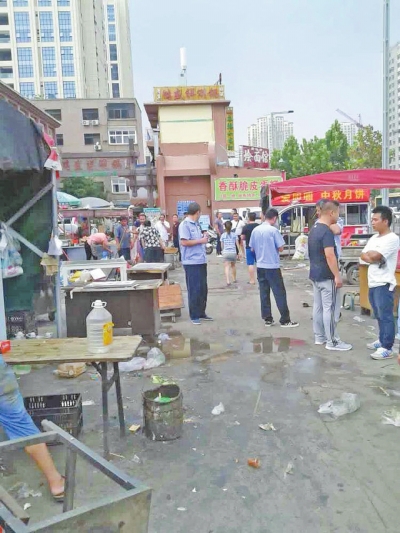 昨天，執(zhí)法人員在京廣路長(zhǎng)江路口整治“僵尸圍擋”及圍擋內(nèi)的攤販。