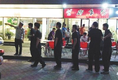 6月13日晚10點，朝陽區(qū)國美第一城附近，一名城管隊員帶領(lǐng)一隊協(xié)管例行巡查街邊大排檔。新京報記者 尹亞飛 攝