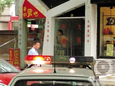 闖入面館的持刀男子與趕來的民警隔著玻璃門對(duì)峙，后店內(nèi)一名女童被其劫持。網(wǎng)友供圖
