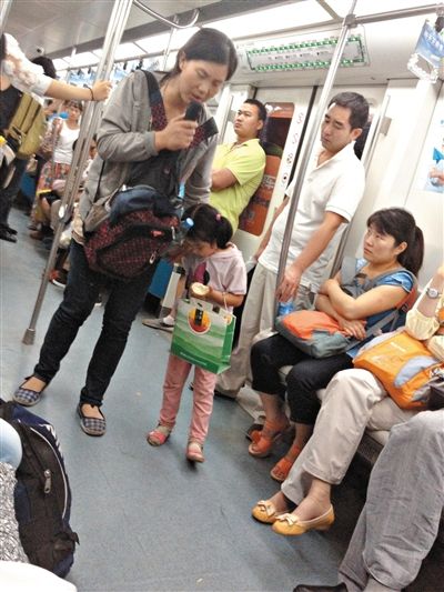 6月27日，舒馨帶一女孩在地鐵十號(hào)線行乞。她因被疑帶多個(gè)不同小孩乞討被警方搜尋。新京報(bào)記者 申志民 攝