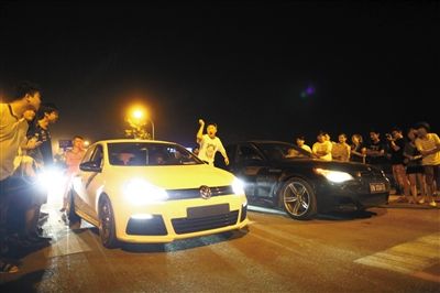 8月24日晚，東壩中街飆車現(xiàn)場(chǎng)，兩輛車并排等待出發(fā)指令，旁邊許多愛好者前來觀看比賽。新京報(bào)記者