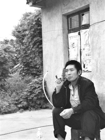 9月12日，陳文才在自己的出租屋旁抽煙。新京報(bào)記者 朱柳笛 攝