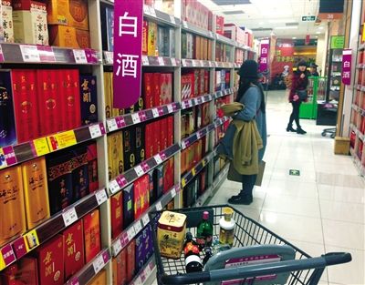 顧客在商場(chǎng)的高檔白酒貨架前駐足挑選。春節(jié)臨近，受“禁令”影響，以高檔白酒為代表的節(jié)日禮品市場(chǎng)面臨考驗(yàn)。記者 王遠(yuǎn)征 攝
