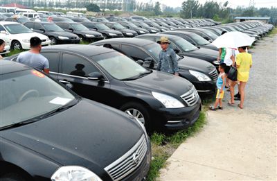 昨日，市民在山東棗莊一家拍賣公司場(chǎng)地上查看待拍賣公車。當(dāng)日，棗莊市103輛公車公開拍賣。新華社記者