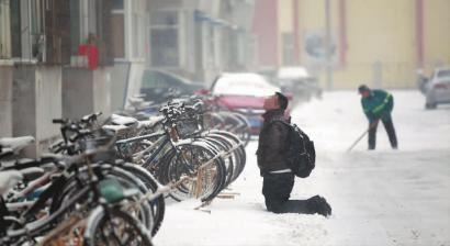 小伙子跪在樓前，一直抬頭看著樓上。 孫立國/攝