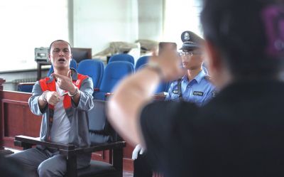 張志國在法庭上用手語回答提問。記者 蒲東峰攝