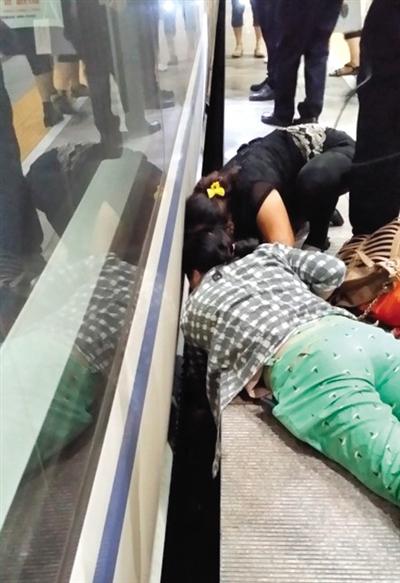一女子趴在站臺(tái)上，救跌入列車和站臺(tái)間隙的男童。網(wǎng)友璀璨的星月夜 攝