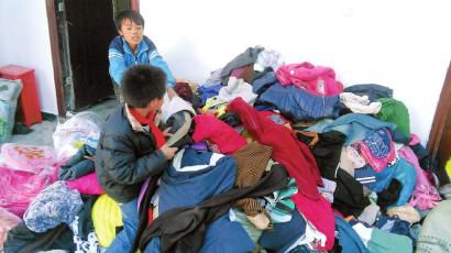 學(xué)生在幫忙整理收到的捐贈(zèng)衣服。得石中心校供圖