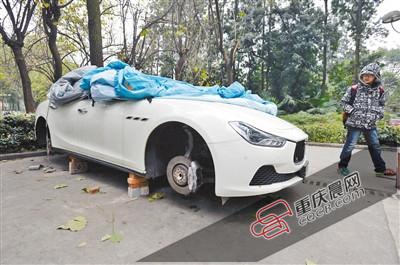 昨日，停放在重慶大學(xué)B區(qū)的一輛瑪莎拉蒂豪車被架在幾塊磚頭上，車輪不翼而飛。 重慶晨報(bào)記者 胡杰 攝