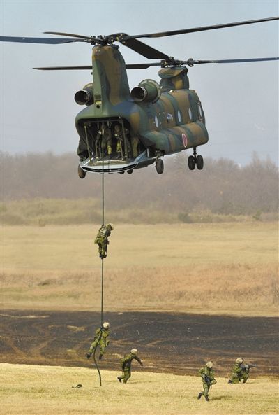 “登島” 1月13日，位于東京的習(xí)志野市，日本自衛(wèi)隊隊員在新年軍演中演練直升機(jī)登島行動。