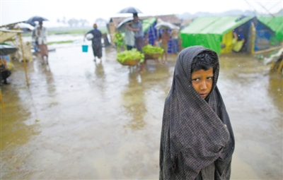 5月14日，緬甸若開(kāi)邦實(shí)兌難民營(yíng)，羅興亞族難民在雨中行走。熱帶風(fēng)暴“馬哈森”即將登陸緬甸，這里的難民開(kāi)始乘船撤離。