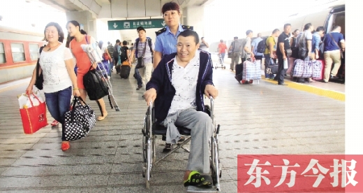 李剛手術(shù)后歸來，在車站工作人員幫助下走出鄭州火車站站臺  東方今報(bào)首席記者 張曉冬 攝