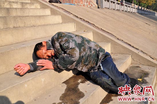 這名男子的衣服以及褲子全濕透了，水從衣褲里流出來，嘴里散發(fā)著濃烈的酒氣。