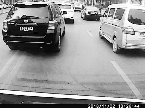 這輛黑色車輛不避讓執(zhí)行緊急任務(wù)的救護(hù)車，并壓著雙黃線變更車道。唐韜/圖