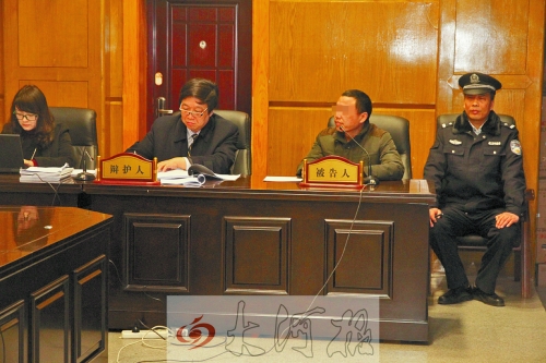 庭審現(xiàn)場，被告人坐在律師身旁為自己辯護。