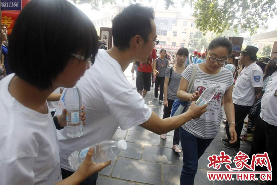 志愿者為剛剛考試完的考生送上1瓶冰凍的冰露·純悅，消暑解渴為考生加油
