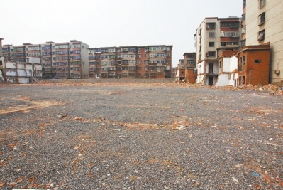 為降塵，旮旯王村拆遷后裸露的地面上鋪了一層石子。