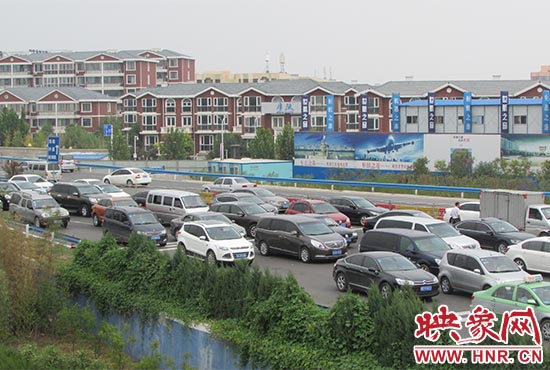 記者看到鄭州機場收費站口車輛排隊，與此形成鮮明對比的是，路的對面（另一半幅）卻車輛較少，通行順暢。