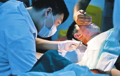 孩子身上有7道傷痕，其中兩道需要縫合，其他的均為擦傷，醫(yī)生正對(duì)他施治。
