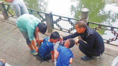男孩被救出后，圍觀群眾幫他控水換衣服。