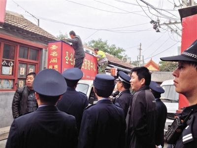 昨日下午,東城區(qū)工商、城管、公安等部門,對(duì)雍和宮附近的預(yù)測(cè)中心進(jìn)行清理整頓,站在車頂?shù)膬擅と苏鸪患摇邦A(yù)測(cè)中心”的招牌。因雍和宮、白云觀等文化景點(diǎn)外聚集大量算命先生,被媒體稱為“算命一條街”。本版攝影/新京報(bào)記者 李寧 攝
