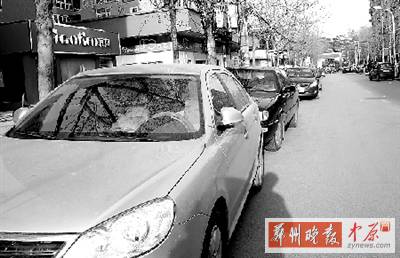 友愛路，路邊停了一排車，本來(lái)不寬的路就變得更窄了。