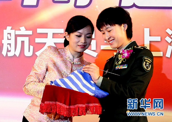11月1日，航天員劉洋（右）在為“愛心”毛衣編織最后的收尾針。