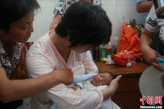 圖為陜西富平“產(chǎn)科醫(yī)生拐賣嬰兒”一案中的被拐嬰兒于8月5日中午在該縣婦幼保健院由當?shù)鼐浇挥谄涓改?。張一?攝