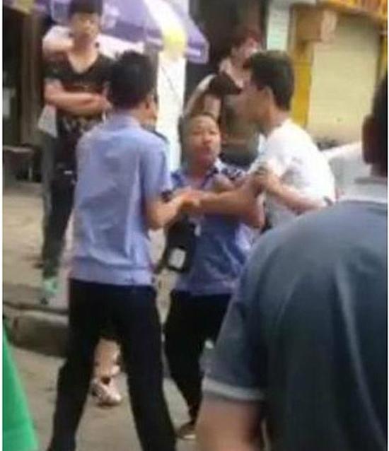 付某（右）與城管執(zhí)法人員廝打在一起。