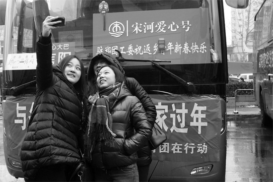 昨天上午8時(shí)，鄭州正道中環(huán)百貨廣場(chǎng)，準(zhǔn)備回家的老鄉(xiāng)在愛心大巴車前合影留念