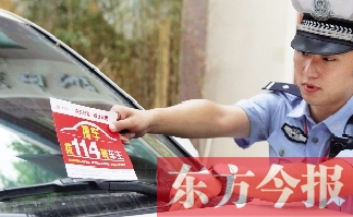交警將“挪車(chē)請(qǐng)撥打114轉(zhuǎn)車(chē)主”的提示牌放在路邊?？康能?chē)上