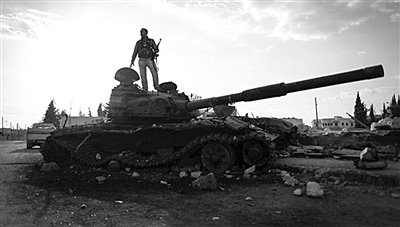 9月8日，敘利亞Zabadani，一名敘利亞反對派武裝人員站在廢棄的政府軍坦克上。