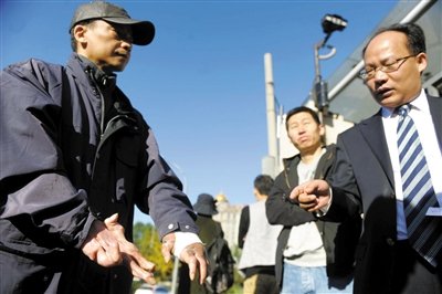 常林鋒在法院外展示雙手，他稱被燙傷的手因刑訊逼供且未得到及時(shí)救治