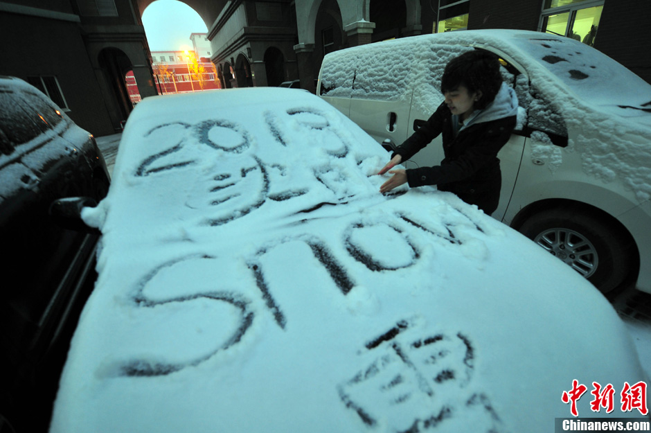 11月18日，行人在車輛的積雪上涂鴉。