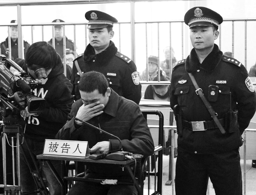 庭審中,29歲的李軍低著頭。