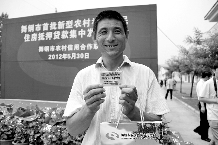 領(lǐng)到貸款，農(nóng)民開心地笑了。