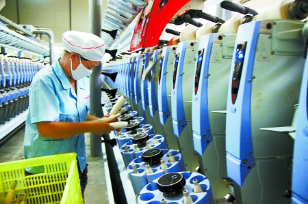 7月3日，在鄧州市永泰棉紡有限公司電腦控制全自動紡紗車間，紡織工人正在生產(chǎn)棉紗。
