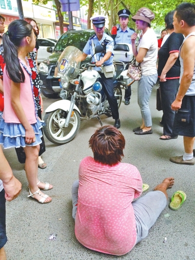 在鄭州優(yōu)勝南路東三街交叉口向東100米處，一名短發(fā)中年女子平躺在路南快車道上，身旁還有一只掉落的拖鞋