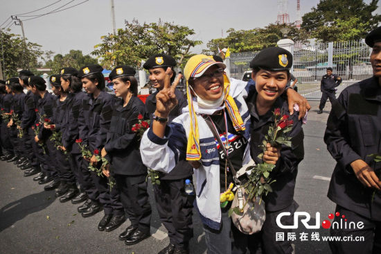2013年12月03日,曼谷總理府與曼谷警署允許反政府示威民眾進(jìn)入,雙方進(jìn)入暫時(shí)“停戰(zhàn)”狀態(tài)迎接泰王生日。曼谷警察總署,女警們手持鮮花送給反政府示威民眾。圖片來源:Manish Swarup/東方IC